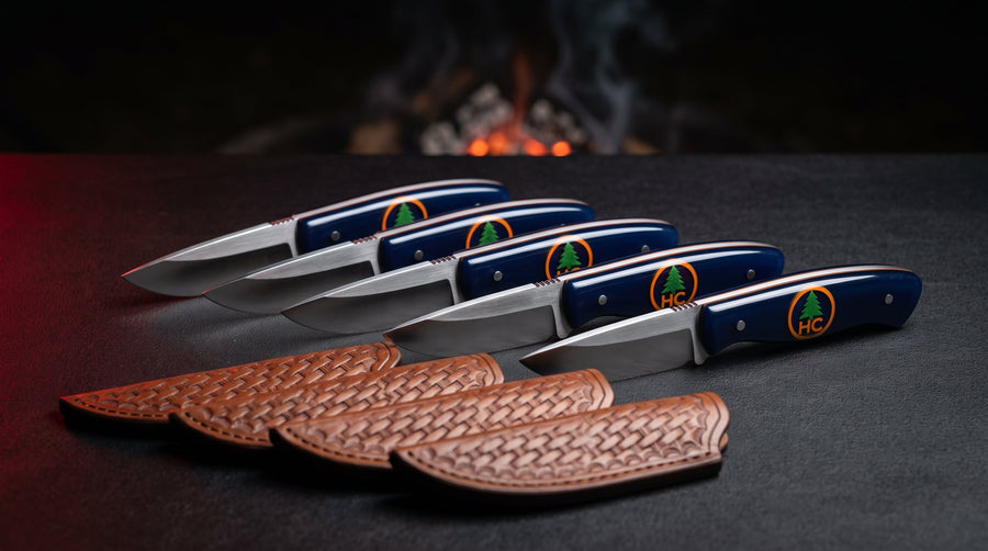 Five matching EDC knives with navy resin handles and a sample pine tree logo above five basket weave sheaths