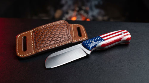 Bull cutter knife with a full resin American flag handle beside a basket weave pancake sheath