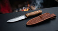 Hand forged Kephart knife with a 4.5 inch flat ground blade, oak handle and a stamped leather sheath