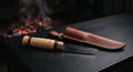 Hand forged puukko knife with a straight 4 inch blade, curly birch barrel handle and a plain leather pouch sheath