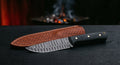 Damascus Kephart knife with a ladder pattern blade, black micarta handle and a stamped leather sheath