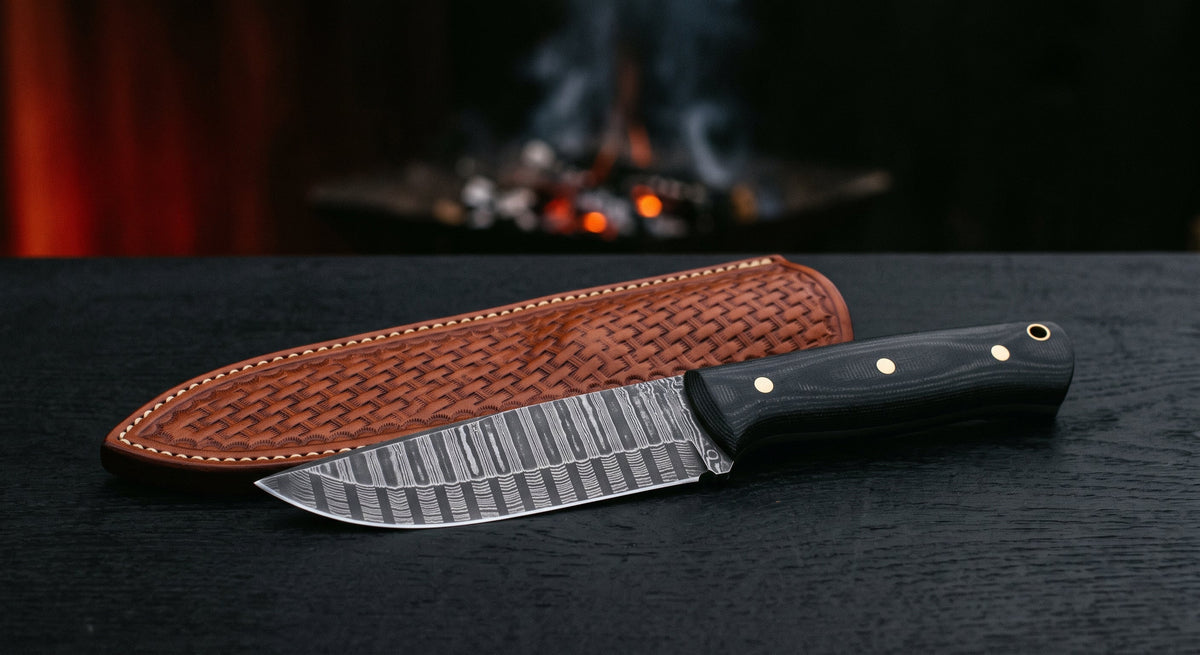 Damascus Kephart knife with a ladder pattern blade, black micarta handle and a stamped leather sheath