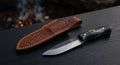 Hand forged bushcraft knife with a scandi ground blade, water buffalo horn handle and a stamped leather sheath