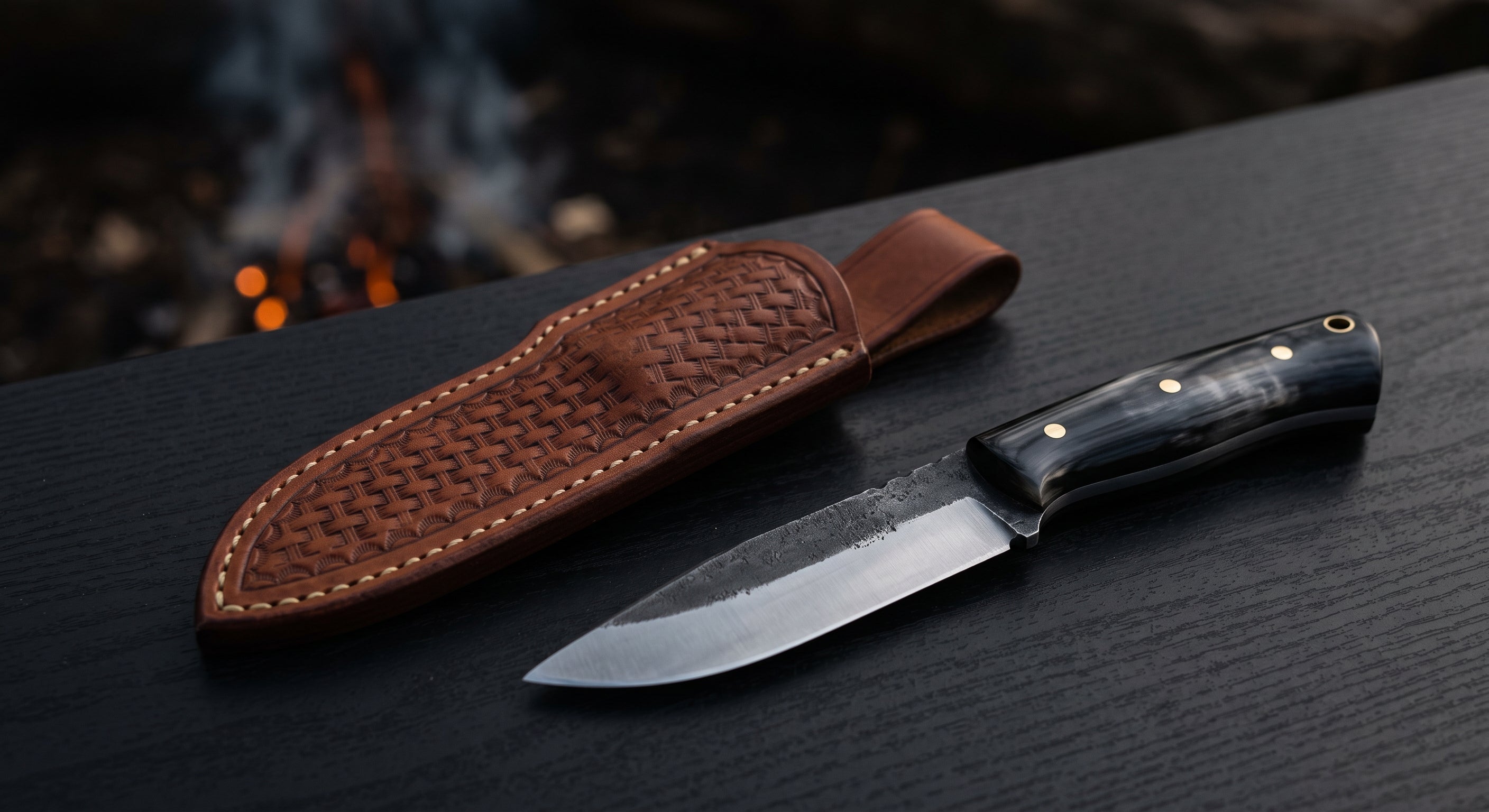 Hand forged bushcraft knife with a scandi ground blade, water buffalo horn handle and a stamped leather sheath
