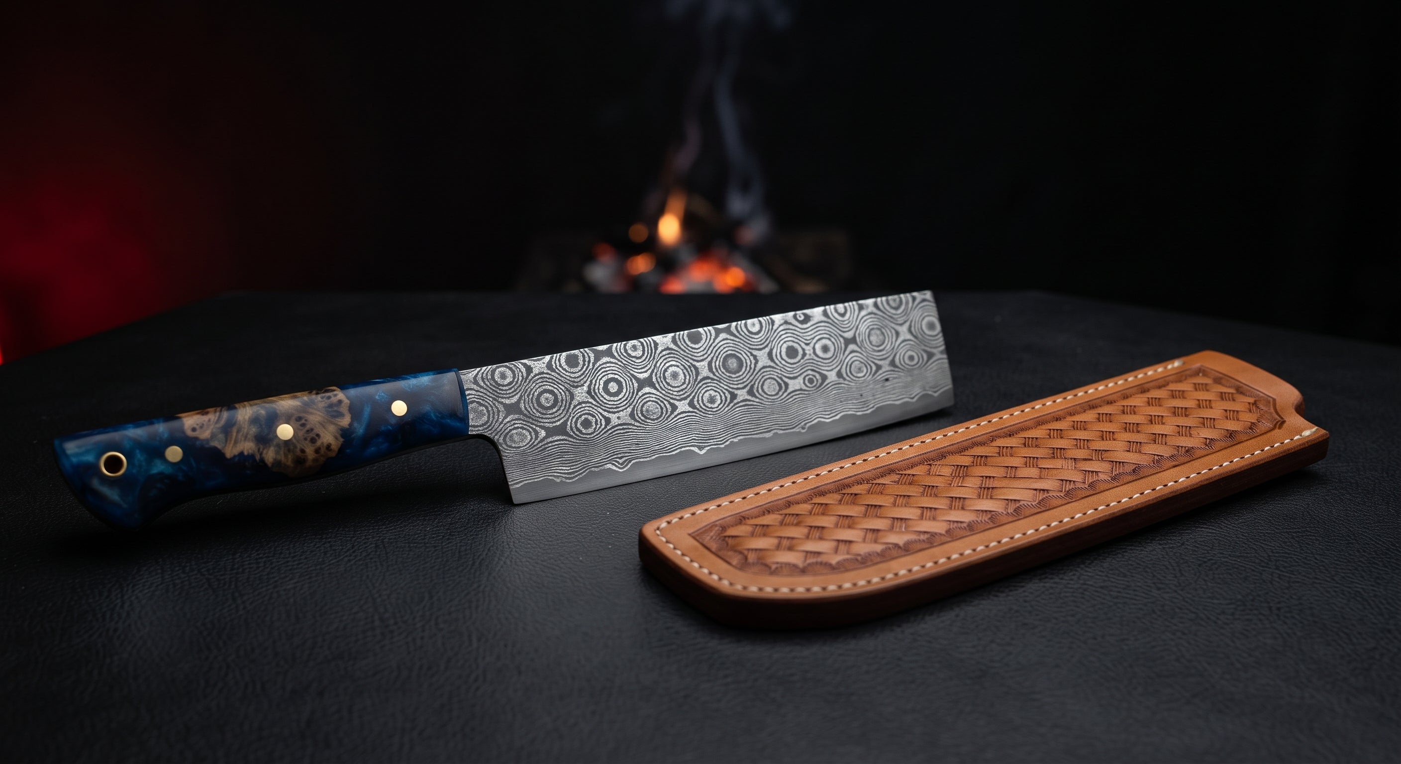 Damascus nakiri knife with a tall straight edged raindrop pattern blade and a burl wood and blue resin handle