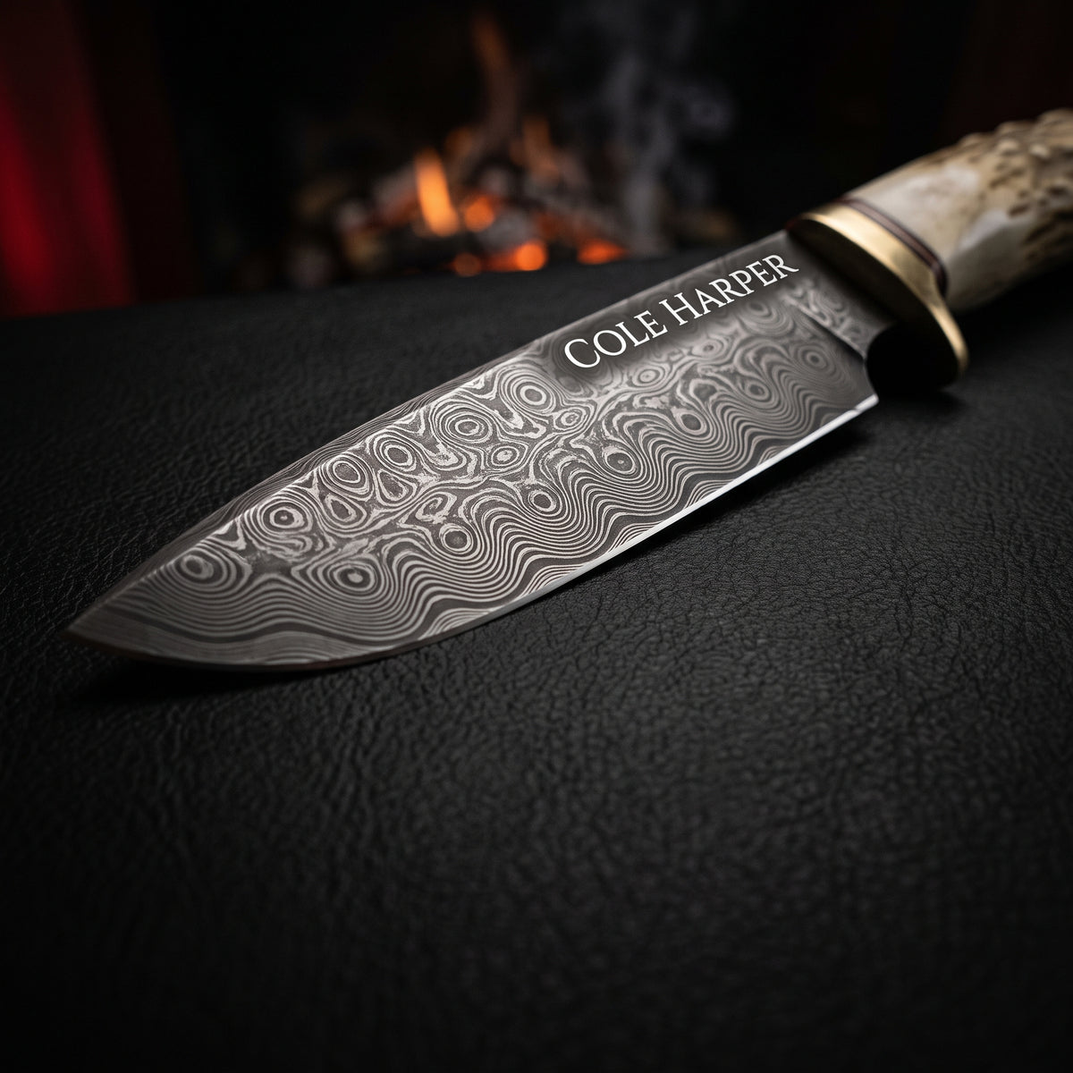 Damascus hunting knife with a raindrop pattern blade laser engraved with the name Cole Harper, stag antler handle and brass bolster