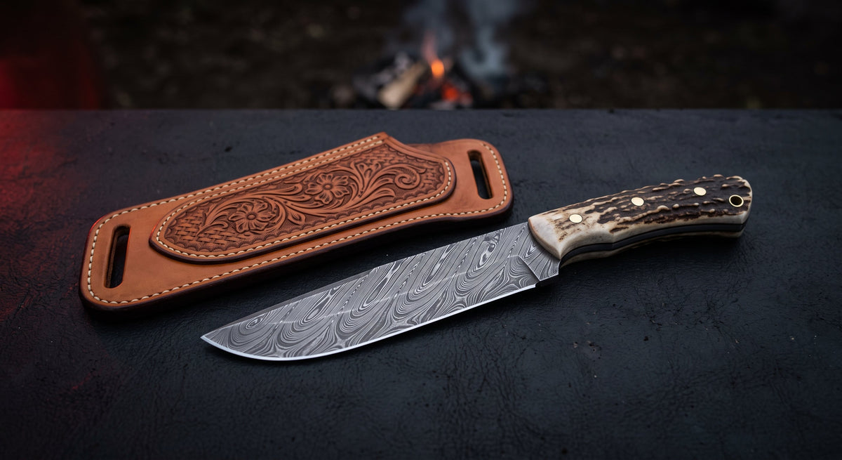 Damascus cowboy knife with a twist pattern drop point blade, stag antler handle and a hand carved pancake sheath
