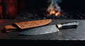 One of a kind Damascus chef knife with a raindrop pattern blade, black buffalo horn handle and a brass bolster
