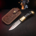 Damascus folding knife with black buffalo horn handle and tooled leather pouch