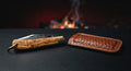 Closed hand forged slip joint folding knife with an olive wood handle, brass bolsters and a leather slip pouch