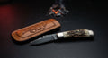Closed hand forged trapper pocket knife with a stag antler handle and nickel silver bolsters