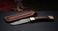 Closed Damascus lock back folding knife with a rosewood handle and brass bolsters