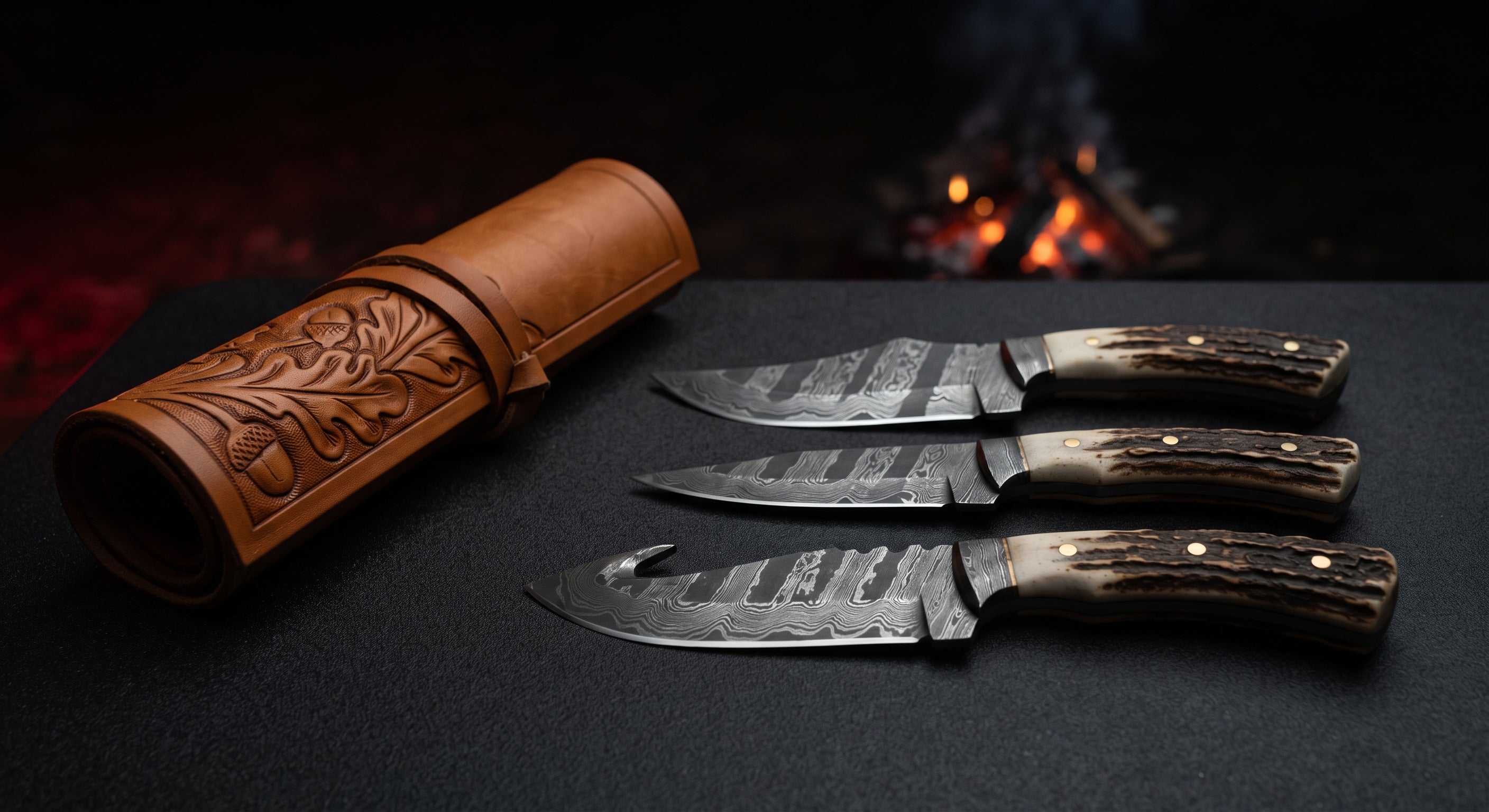 Damascus hunting knife set of three with stag antler handles beside a closed hand carved leather knife roll