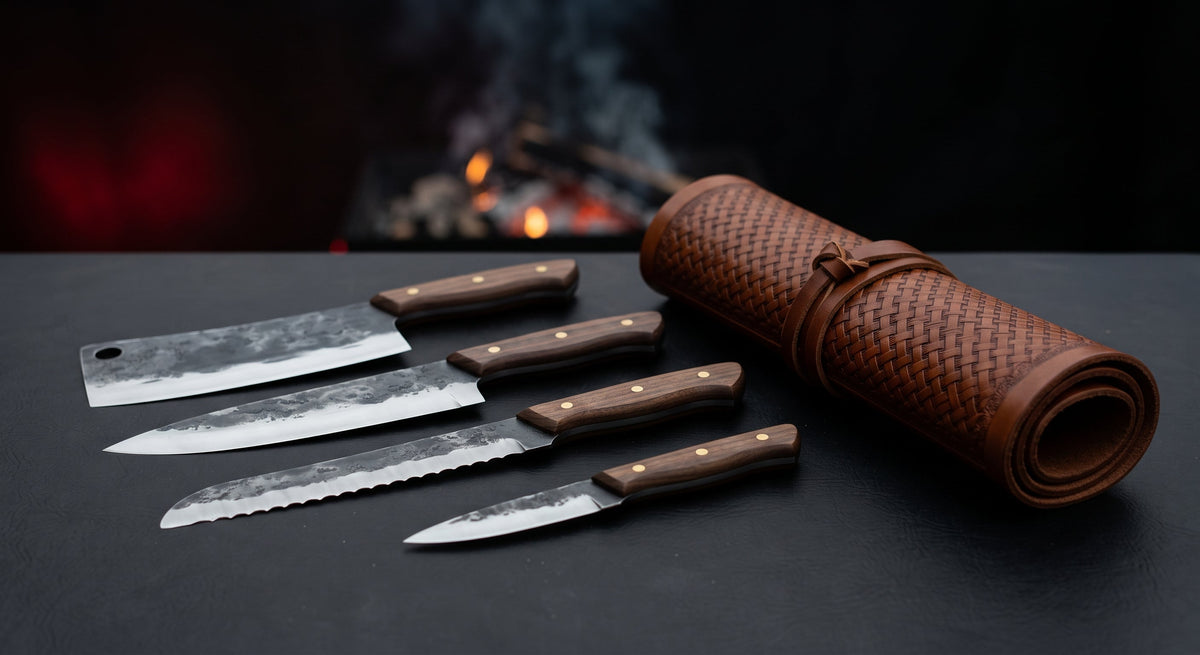 Hand forged kitchen knife set of five with walnut handles beside a closed tooled leather knife roll