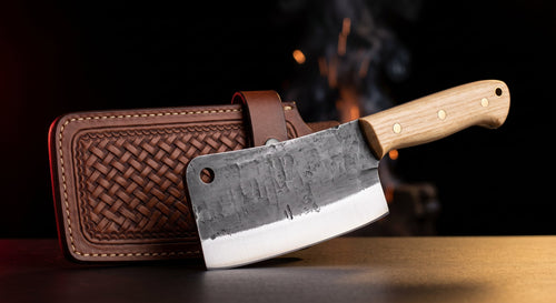 Hand forged bone cleaver with thick spine, hickory handle and tooled leather blade cover