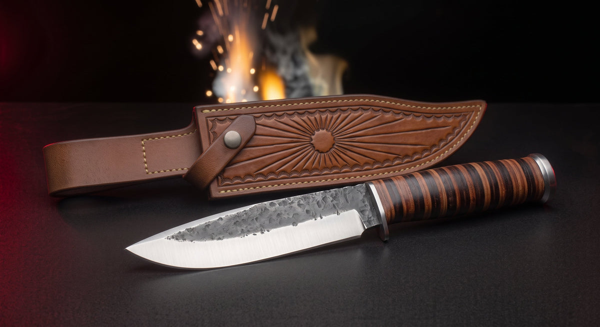 Hand forged carbon steel camp knife with stacked leather handle and tooled leather belt sheath