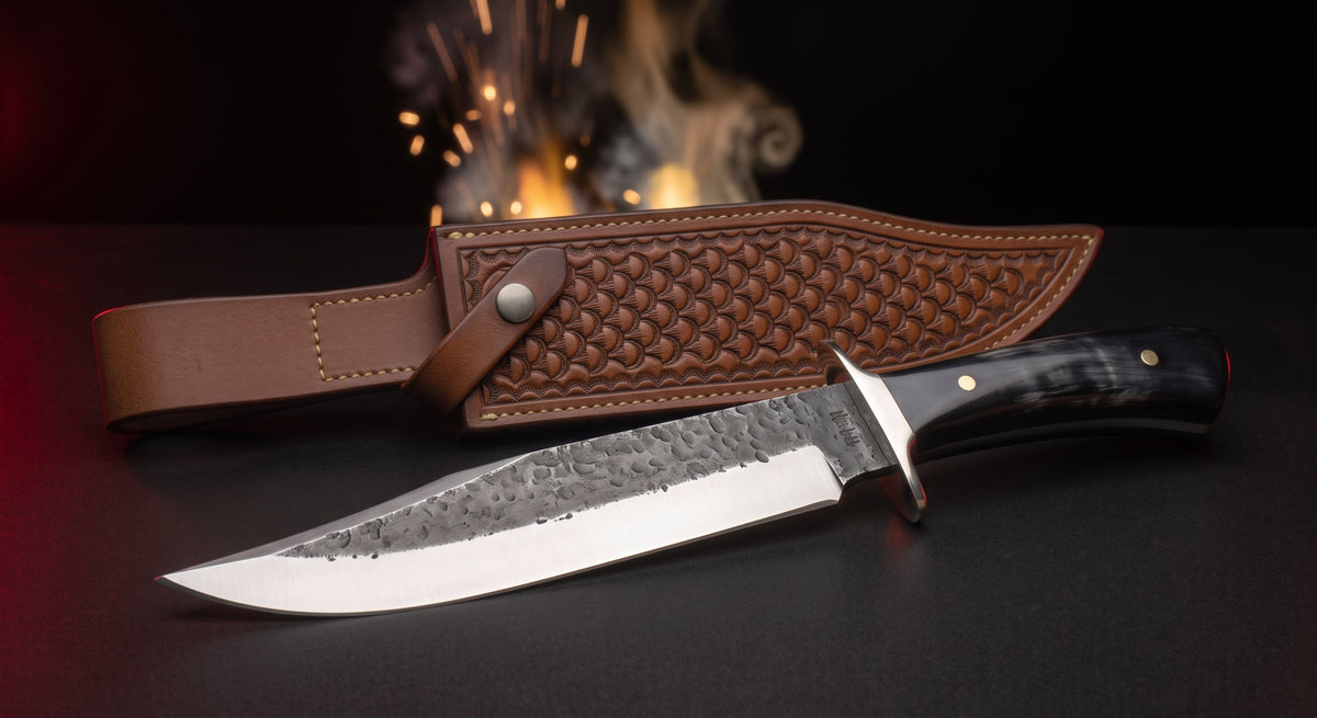 Hand forged carbon steel bowie knife with buffalo horn handle, steel guard and tooled leather belt sheath