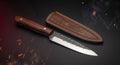 Hand forged carbon steel kitchen knife with rosewood handle and stamped leather sheath
