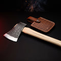 Hand forged carbon steel throwing axe with hickory handle and tooled leather head cover