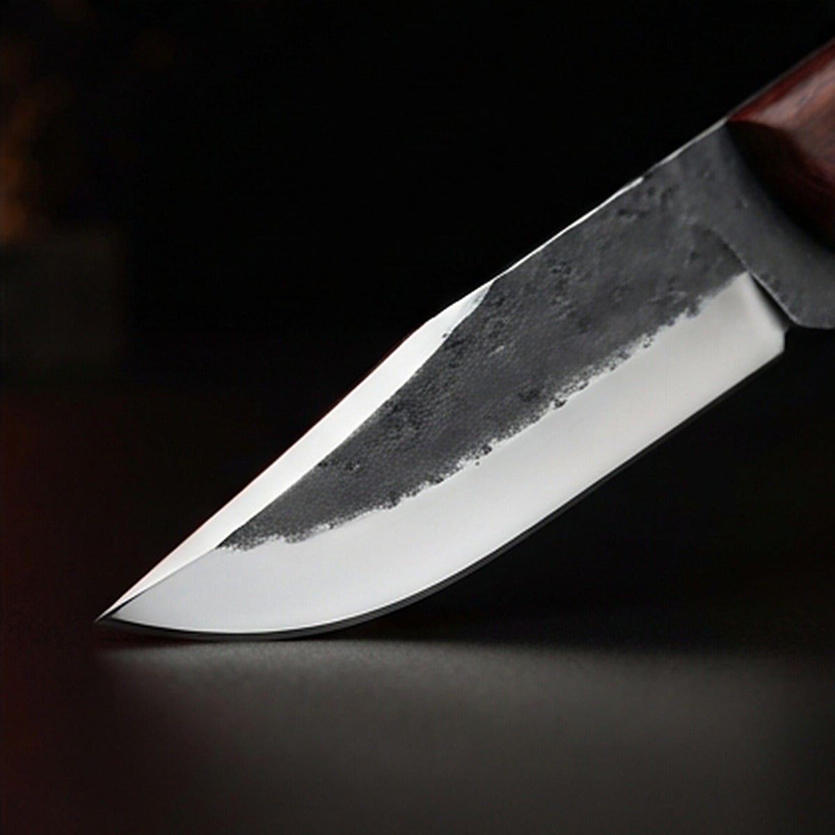 1095 high carbon steel drop point hunting knife with rosewood handle and brass pins, cutting edge and tip detail