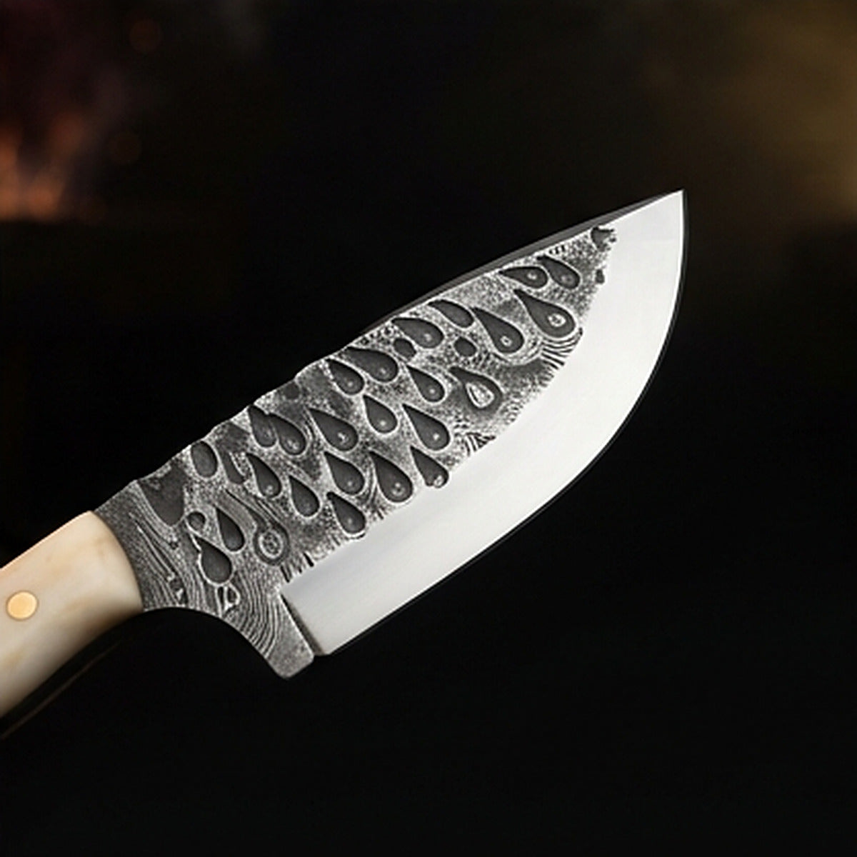 Damascus steel skinning knife with polished camel bone handle and brass pins, cutting edge and tip detail