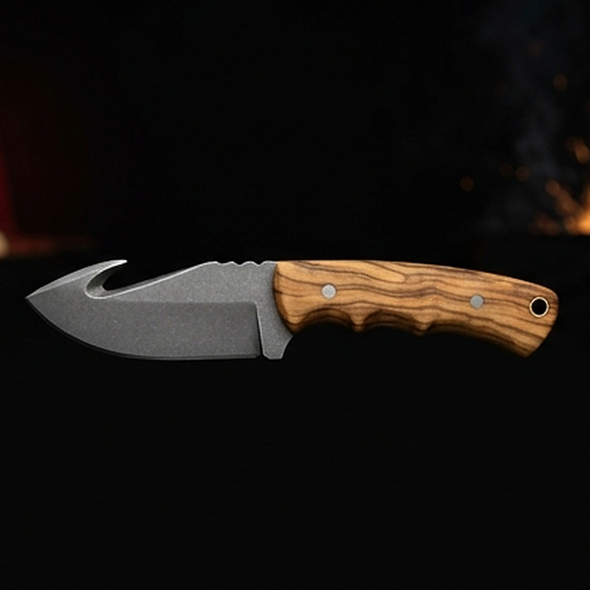 D2 tool steel gut hook skinning knife with olive wood handle and steel pins, left side profile