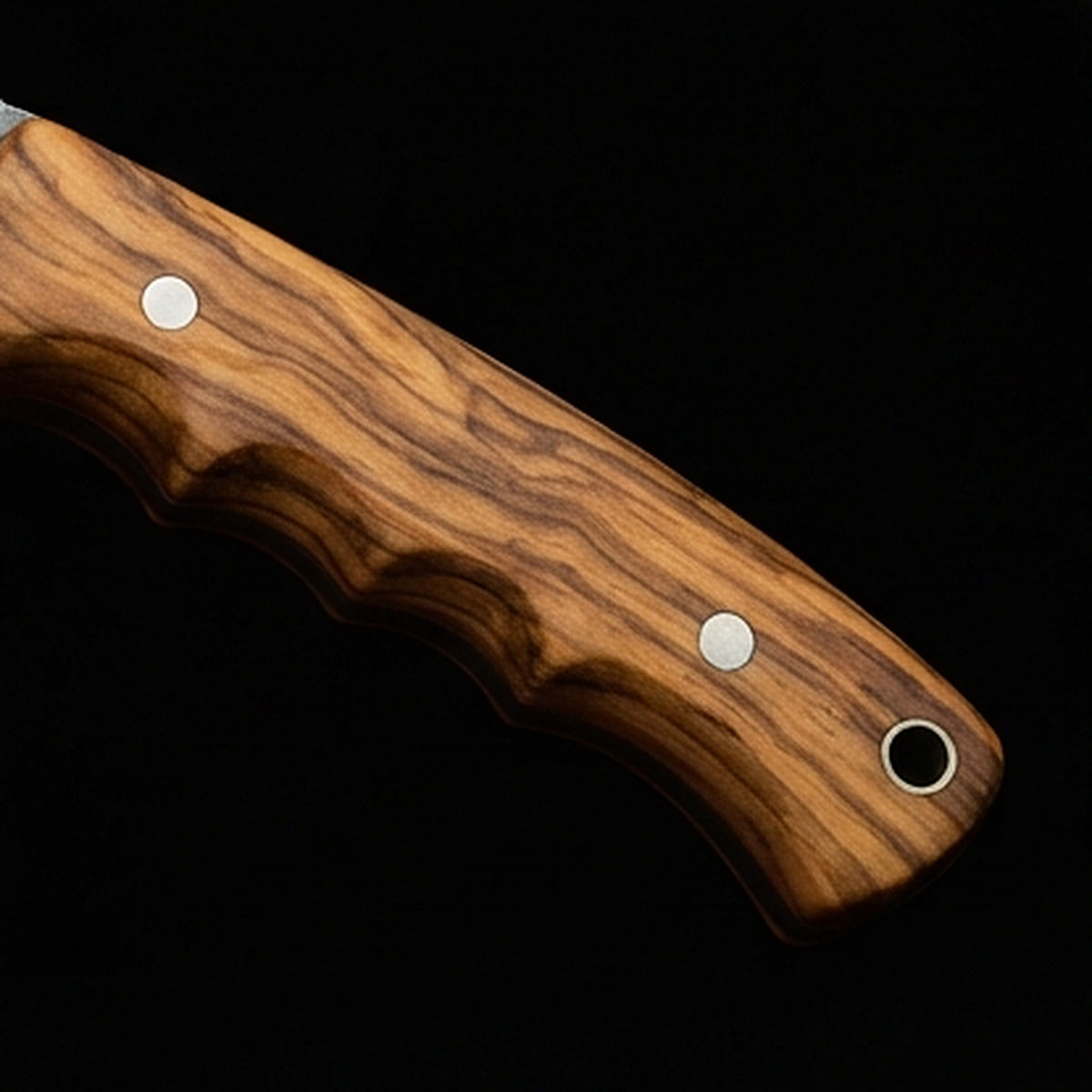 D2 tool steel gut hook skinning knife with olive wood handle and steel pins, handle close up