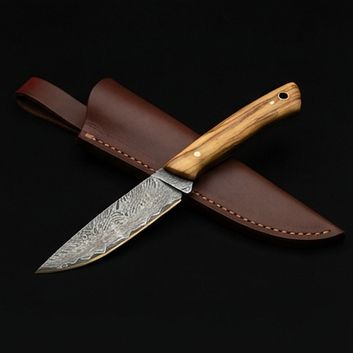 Damascus steel bird and trout knife with slim olive wood handle and brass pin, with its leather sheath