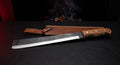 Hand forged machete with an 18 inch straight blade, squared tip, oak handle and a stamped leather sheath
