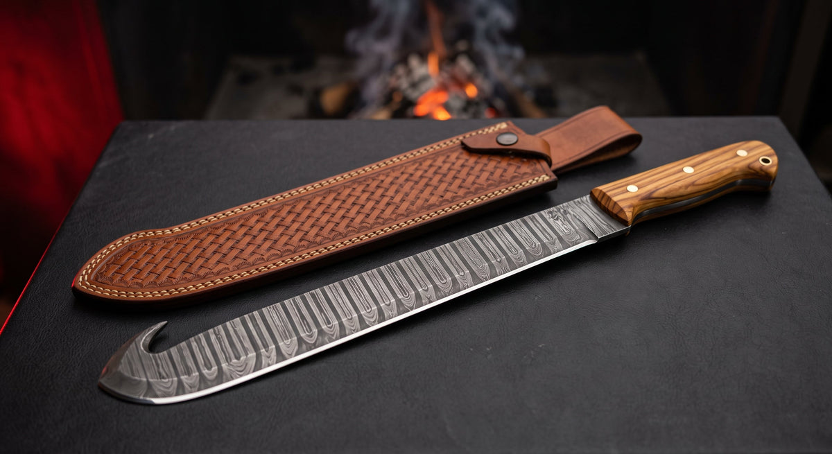 Damascus cane machete with a ladder pattern blade, hooked beak at the tip, olive wood handle and a stamped leather sheath