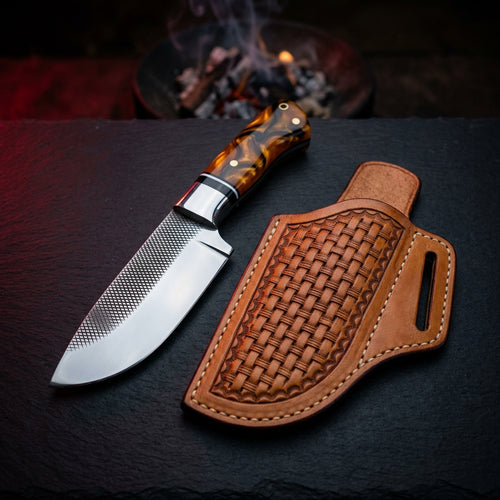 Rasp bull cutter knife with amber and black swirl resin handle beside a basket weave pancake leather sheath