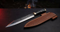 Hand forged seax knife with a straight edge, low point, water buffalo horn handle and a stamped leather sheath