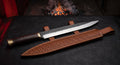 Hand forged langseax with an 11 inch straight edged blade, stacked leather handle and a stamped leather sheath