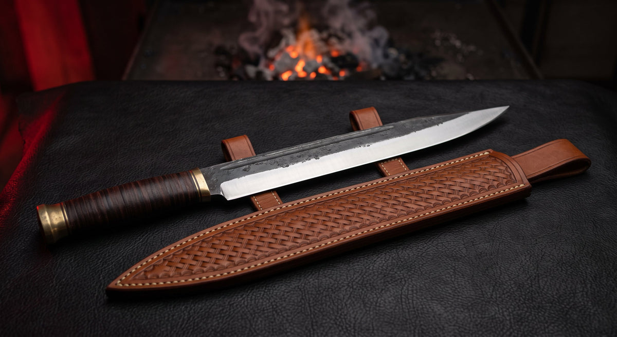 Hand forged langseax with an 11 inch straight edged blade, stacked leather handle and a stamped leather sheath