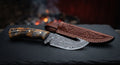 Damascus gut hook skinner with a twist pattern blade, notch cut into the spine and a ridged ram horn handle
