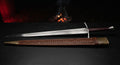 Hand forged longsword with a fullered blade, long two hand grip and a stamped leather scabbard