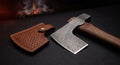 Damascus throwing axe with a twist pattern head, walnut handle and a stamped leather cover