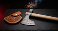Damascus tomahawk with a ladder pattern head, ash handle and a hand carved leather head cover