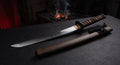 Hand forged clay tempered wakizashi with a visible hamon, brown ito wrap and a wooden matte brown lacquer saya